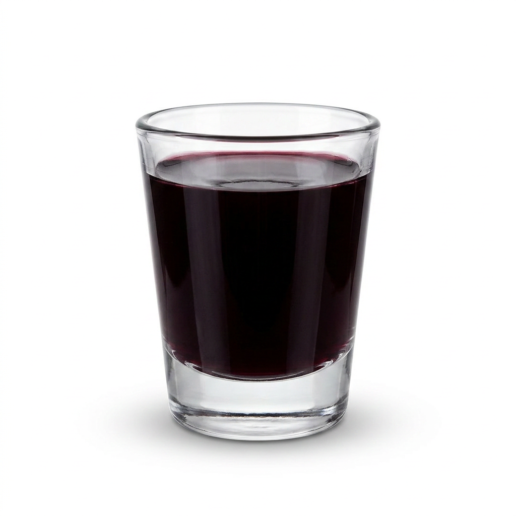 A small shot glass filled with deep purple blueberry juice